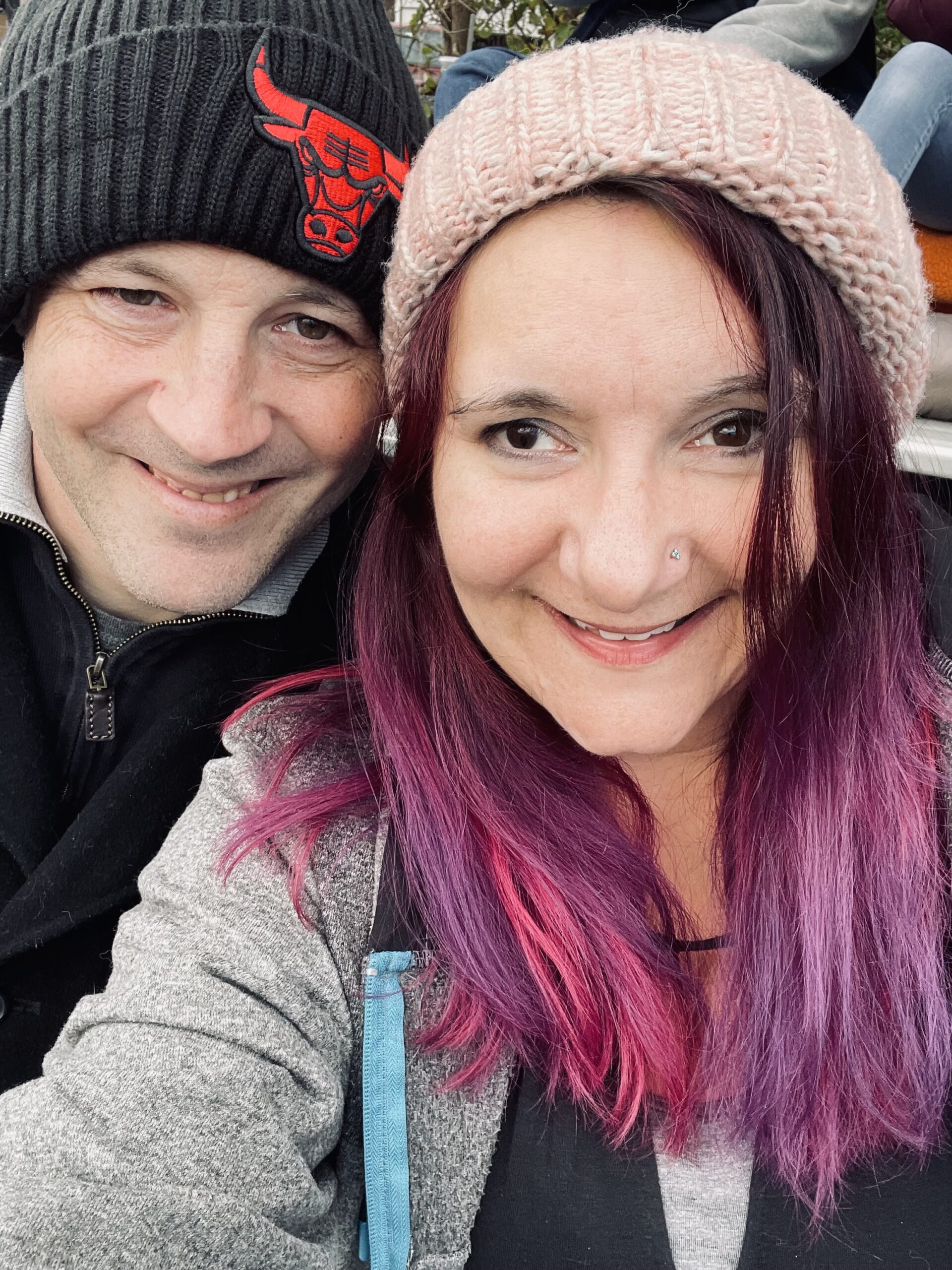 connie and Dave from lyrical lens events in winter hats smiling an in love.
