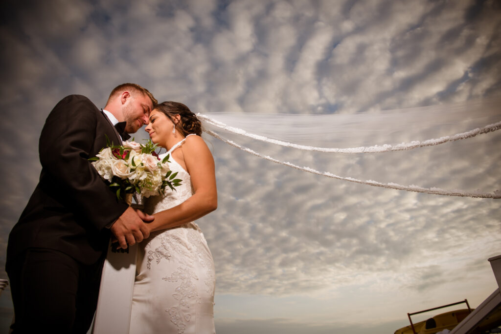 CT wedding photography bride veil in wind dramatic sky Waters Edge Resort Westbrook CT