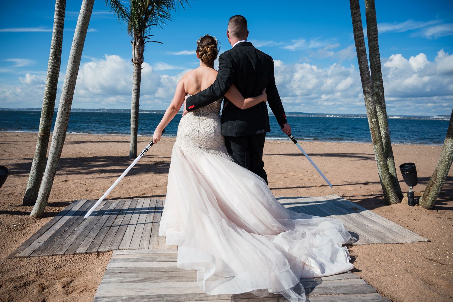 Couple arm in arm holding light sabers on the beach anythony's ocean view New Haven CT
