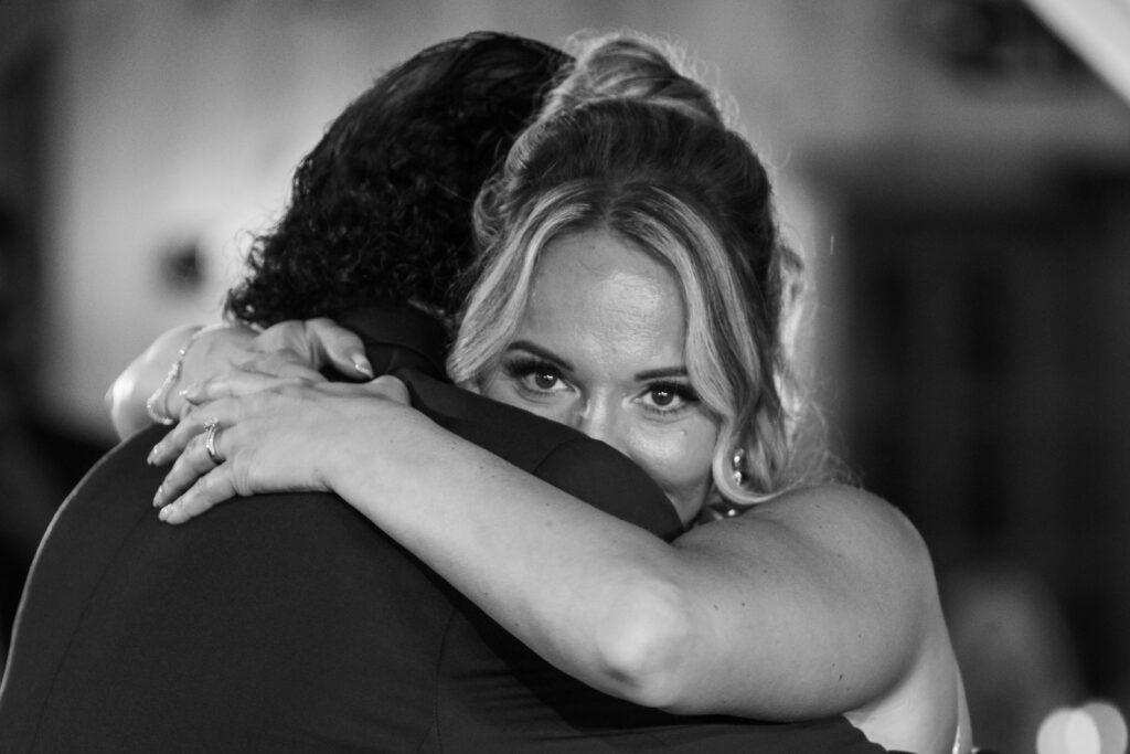 Tearful bride embracing her father during their dance at a Stonehurst at Hampton Valley wedding in Hampton CT, black and white